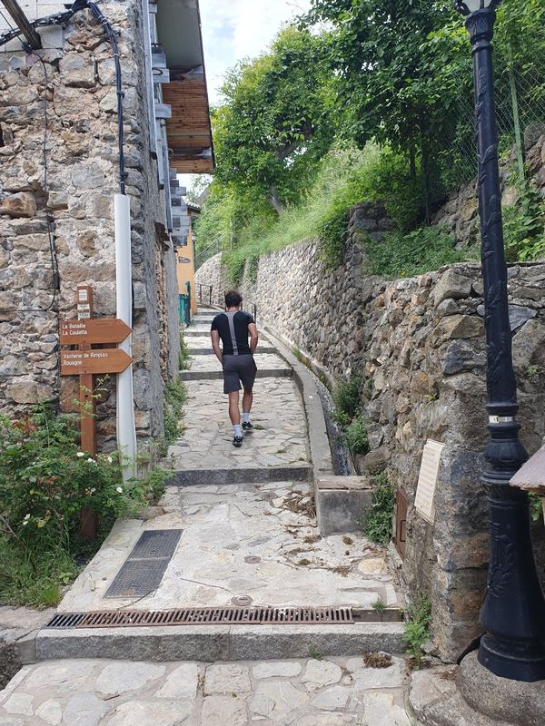 Gepflasterte Treppengasse in Rimplas mit Wegweisern und Laterne