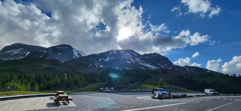 Passhöhe des Col de Vars mit Schneegipfeln und hohen Wolken im Gegenlicht