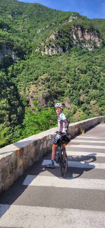Markus auf dem Rad an einer Steinbrüstung über der bewaldeten Schlucht